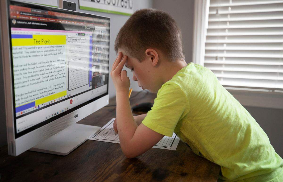 Seven-year-old Bryce Manus studies in front of the computer in his room on Friday, March 26, 2021in Cary, N.C. After almost a year of virtual studies due to the COVID-19 pandemic, Bryce’s mother is ready for her son to return to in-person learning.