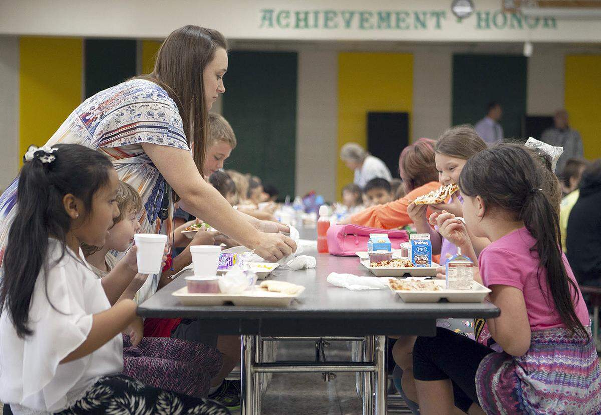 First grade teacher Wendy Stewart hands meals to her students in fall 2018 at Blue Ridge School in Cashiers in Jackson County. A blanket free-lunch program at the school avoids the issue of lunch debt, which is a problem for many other schools. Nick Haseloff / Carolina Public Press