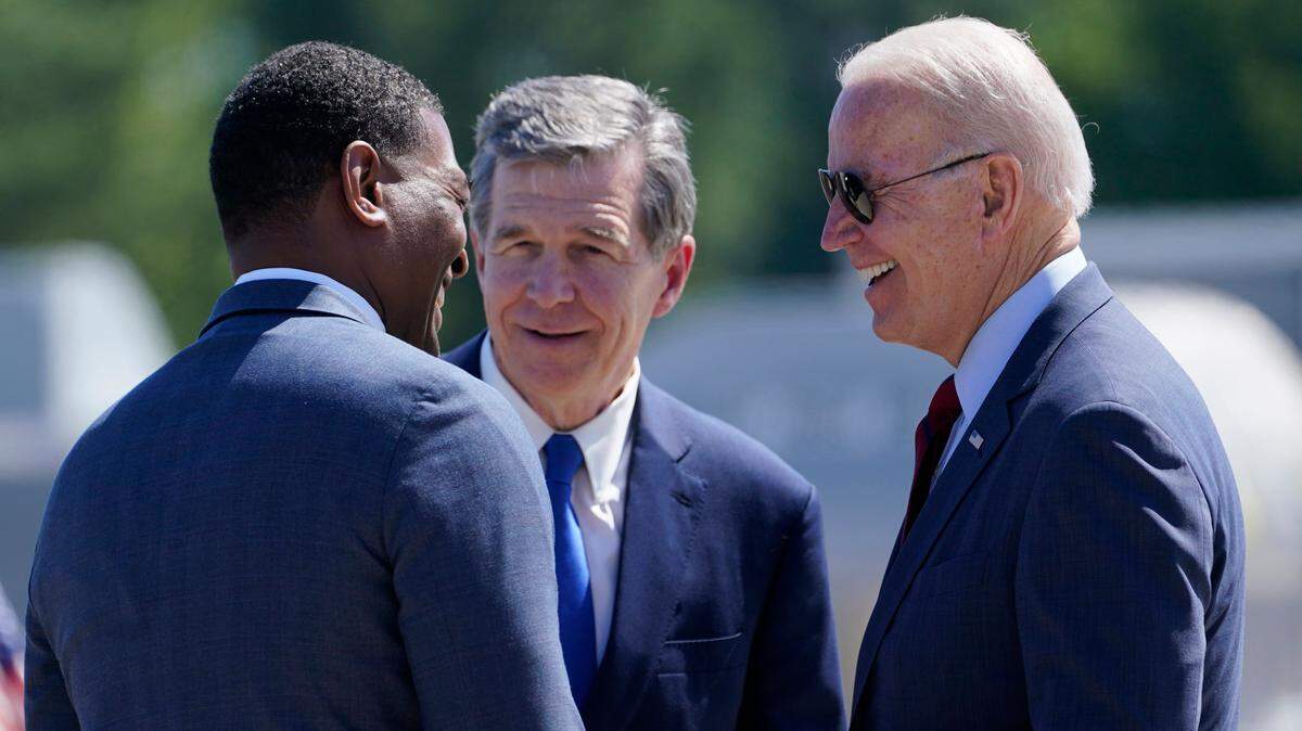 President Joe Biden talks with North Carolina Gov. Roy Cooper and EPA Administrator Michael Regan, after arriving at Raleigh-Durham International Airport, Raleigh, N.C., Thursday, June 24, 2021. Biden is in North Carolina to visit a mobile vaccination unit and meet with frontline workers and volunteers.