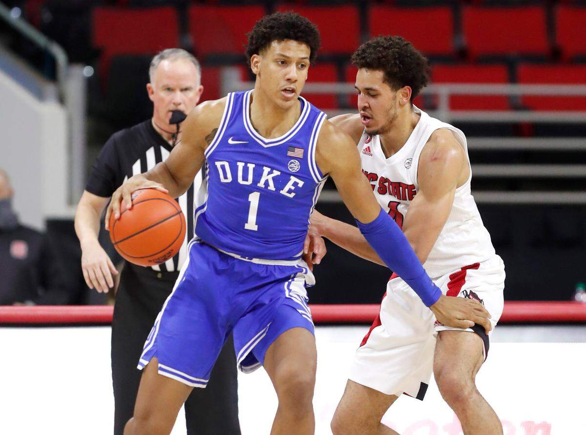 Duke’s Jalen Johnson (1) looks for space as N.C. State’s Jericole Hellems (4) defends during the first half of N.C. State’s game against Duke at PNC Arena in Raleigh, N.C., Saturday, February 13, 2021.