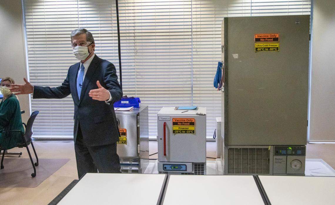 Gov. Roy Cooper tours a room containing freezers where coronavirus vaccines are stored while visiting a large-scale vaccination site at UNC’s Friday Center in Chapel Hill Tuesday, Jan. 19 2021. UNC Hospitals hope to administer 2500 first covid-19 vaccine doses at the Friday Center by the end of this week.