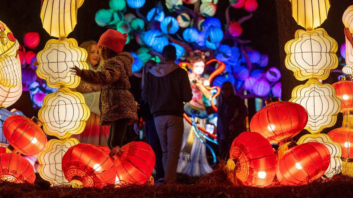 Chelsea Johnson and Christina Boyd immerse themselves in into one of the displays at the NC Chinese Lantern Festival on Tuesday, November 14, 2023 at Koka Booth Amphitheater in Cary, N.C.