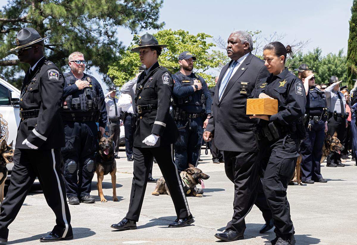 Master Deputy Maria Fuentes, right, walks alongside Wake County Sheriff Willie Rowe following a memorial service for K9 Santos, a Wake County sheriff’s dog, at the Kerr Scott Building on Wednesday, June 14, 2023, in Raleigh, N.C. K9 Santos, a German shepherd, was accidentally shot and killed by a Knightdale police officer after a traffic stop in May.
