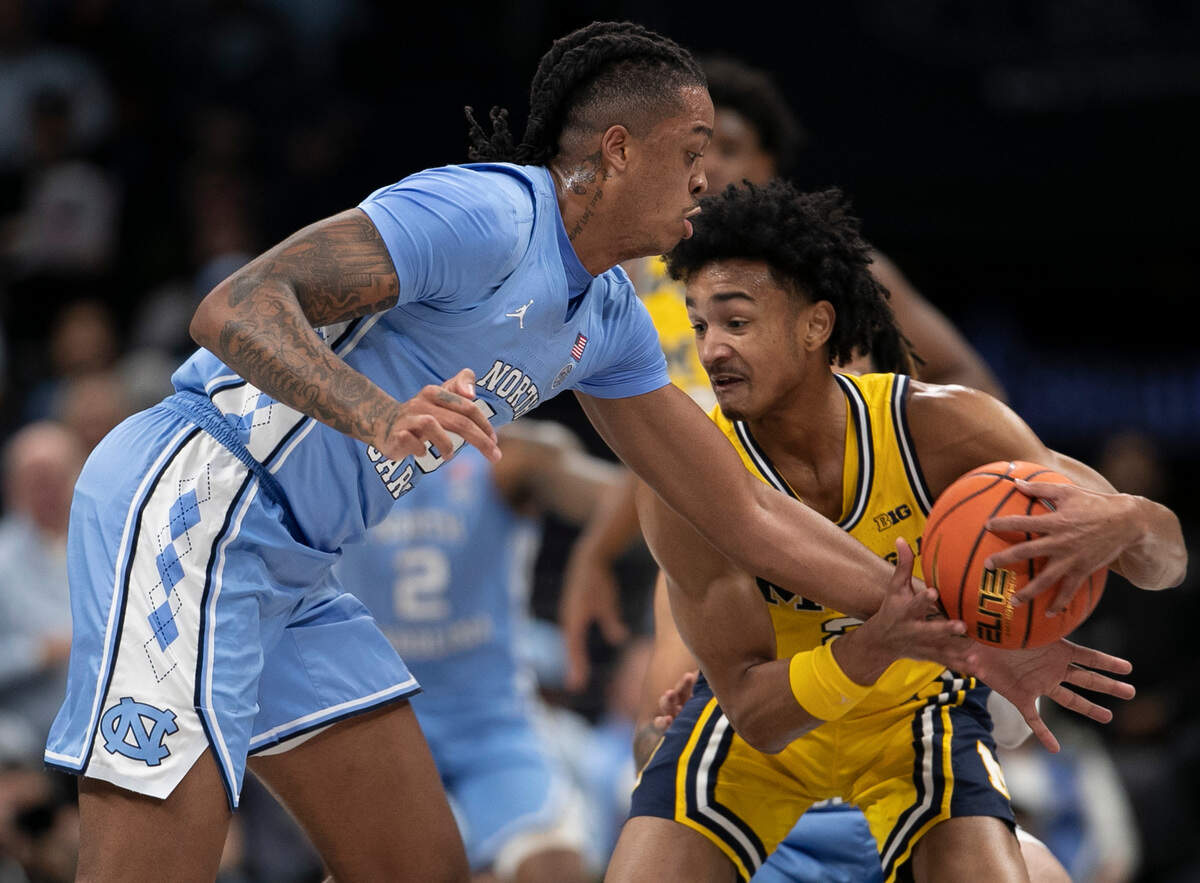 North Carolina’s Armando Bacot (5) tries to a steal from Michigan’s Kobe Bufkin (2) in the first half on Wednesday, December 21, 2022 at the Spectrum Center in Charlotte, N.C.