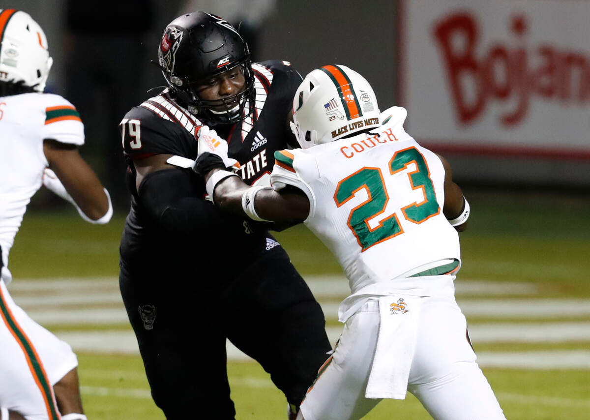 N.C. State offensive tackle Ikem Ekwonu (79) blocks Miami cornerback Te’Cory Couch (23) during the first half of N.C. State’s game against Miami at Carter-Finley Stadium in Raleigh, N.C., Friday, Nov. 6, 2020.