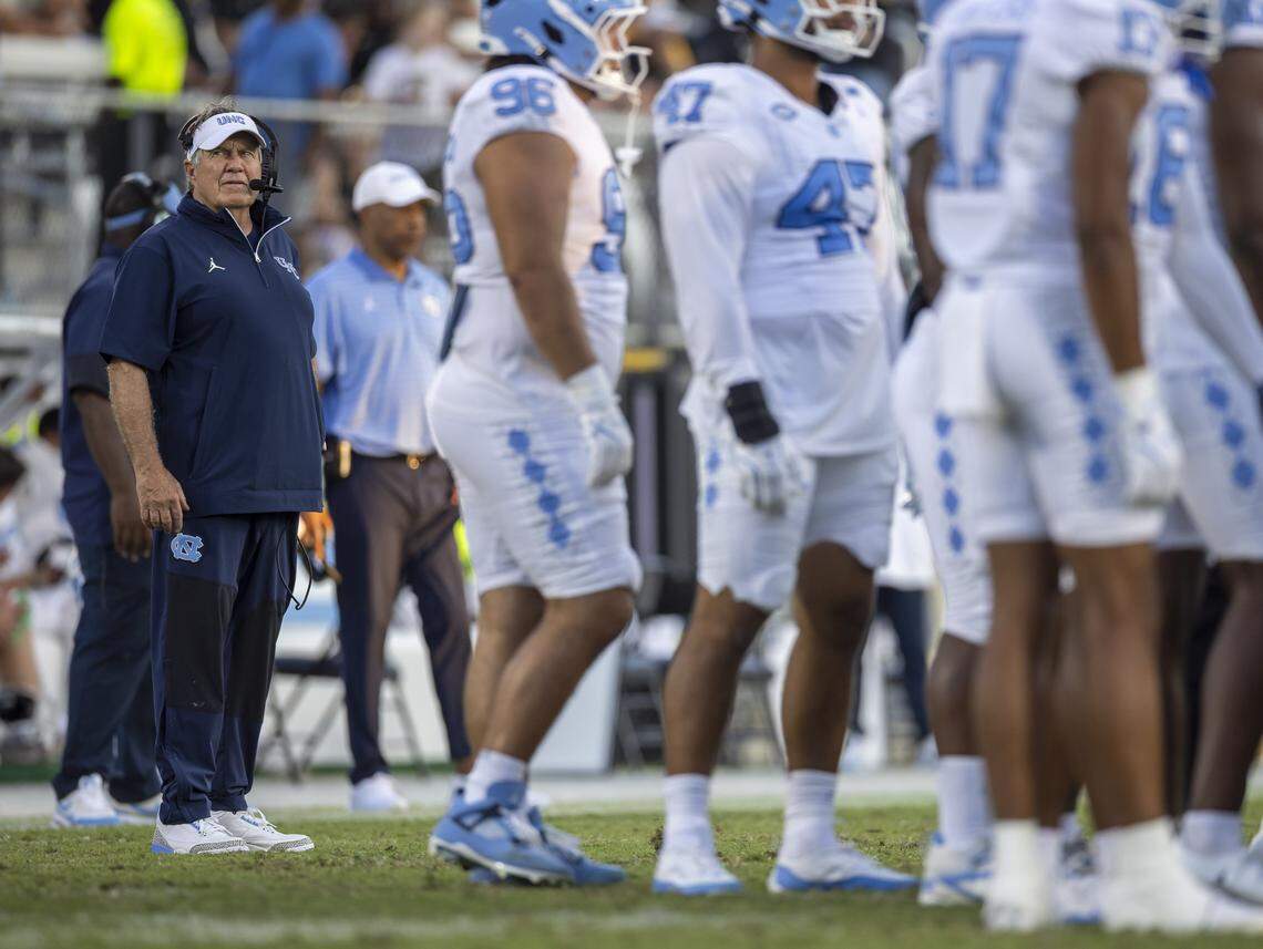 Down 27-9, North Carolina coach Bill Belichick studies the scoreboard during a time-out in the fourth quarter against UCF on Saturday, September 20, 2025 at Acrisure Bounce House Stadium in Orlando, Fla.