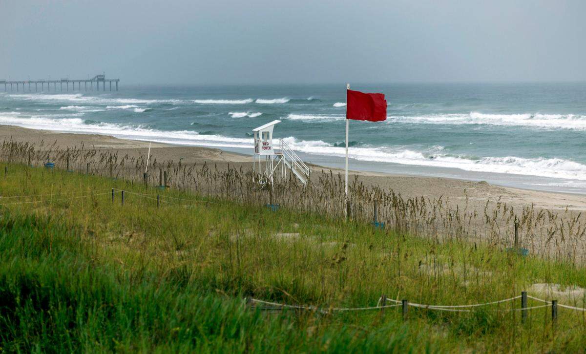Red flags are displayed along the oceanfront as Tropical Storm Ophelia forms off the coast on Friday morning September 22, 2023, in Emerald Isle, N.C.