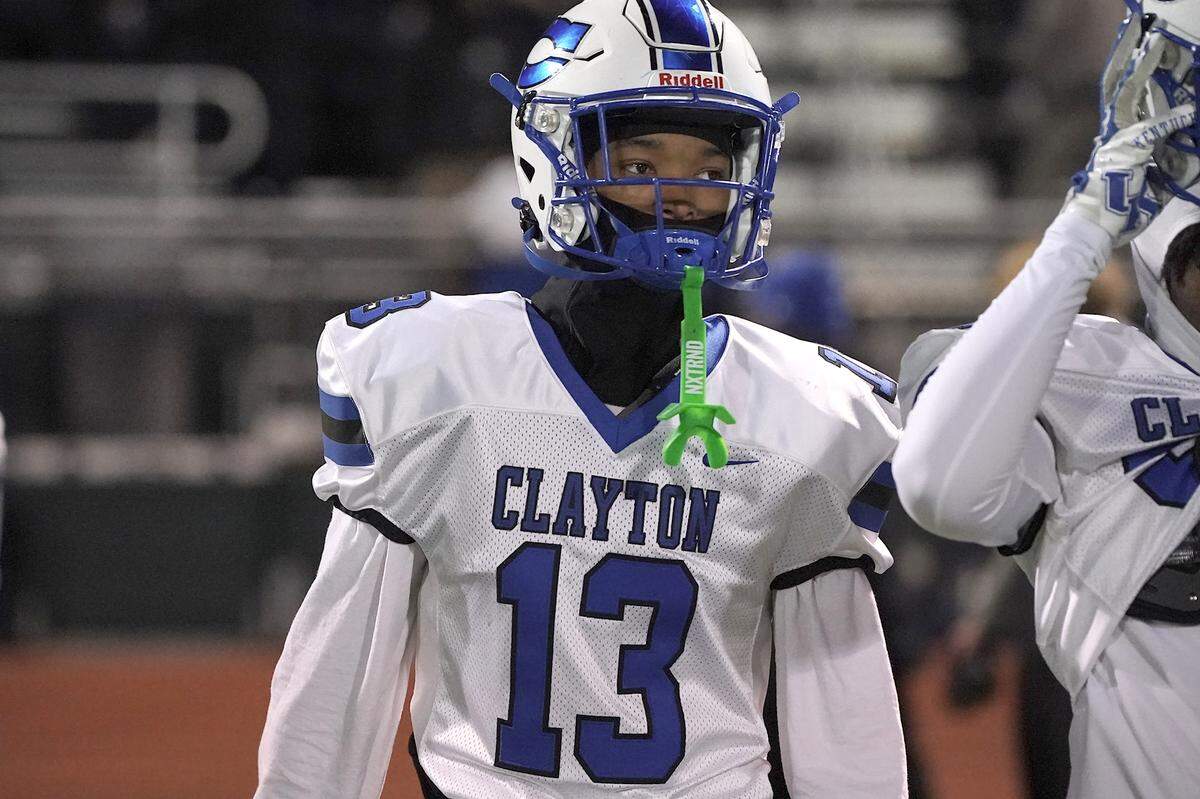 Clayton's Akedran Crumel (13) looks to the sidelines during pregame drills before taking on Cardinal Gibbons in the 7A East Regional Final. The Clayton Comets and the Cardinal Gibbons Crusaders met in the East Regional Final of the NCHSAA 7A Football Championship in Clayton, N.C. on December 4, 2025.
