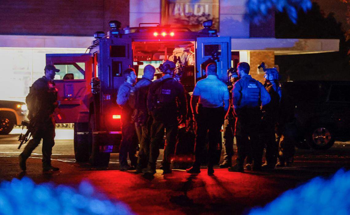 Law enforcement officers congregate outside an armored vehicle at the Aldi on New Bern Avenue in Raleigh after 5 people were shot and killed in the Hedingham Neighborhood and Nuese River Trail area in Raleigh Thursday, Oct. 13, 2022.