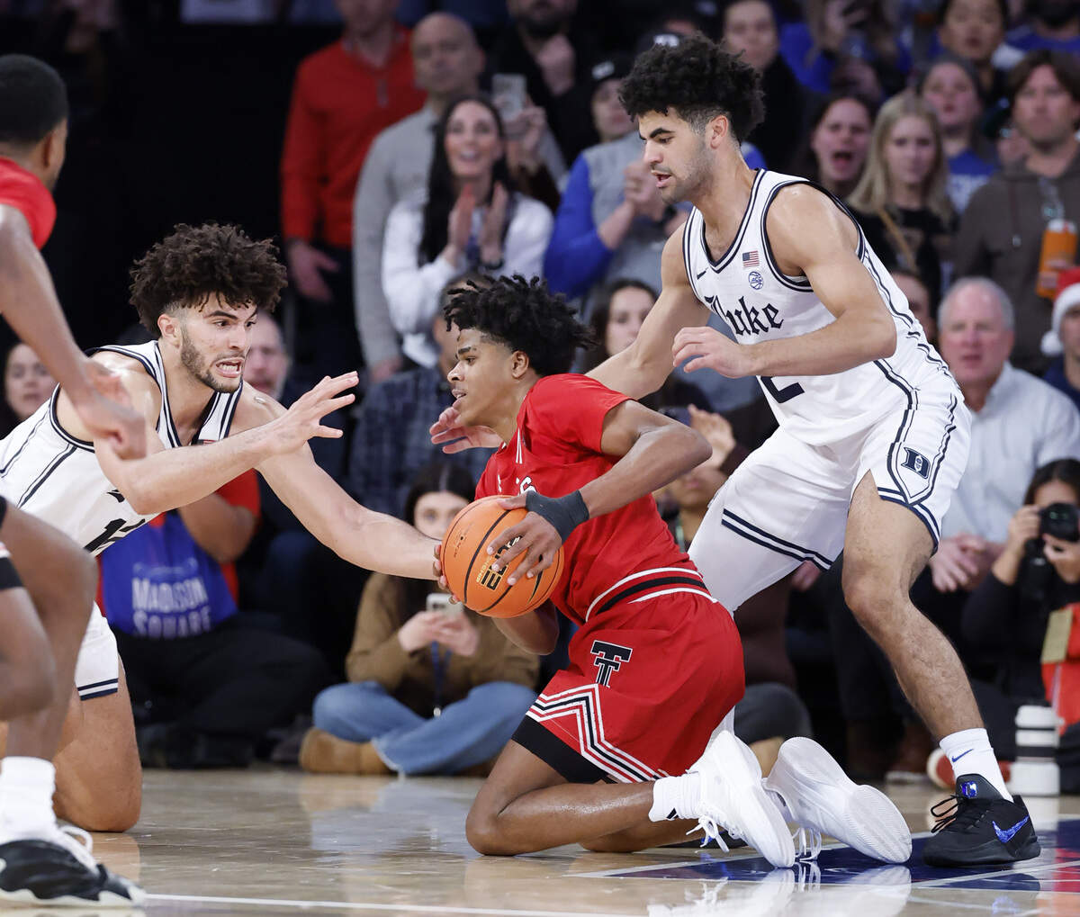 Duke’s Cameron Boozer (12) and his twin brother Cayden Boozer (2) try to take the ball from Texas Tech's Christian Anderson (4) during the second half of Texas Tech’s 82-81 victory over Duke in Madison Square Garden on Dec. 20, 2025. Anderson scored 27 points as Texas Tech came back from 17 points down in the second half to win.