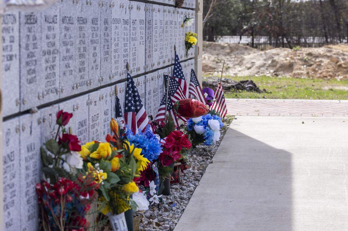 Flowers and flags line the base of a mausoleum at Sandhills State Veterans Cemetery in Spring Lake Tuesday, Feb 21, 2022. North Carolina’s four state-owned veterans cemeteries are behind on maintenance and are short-staffed