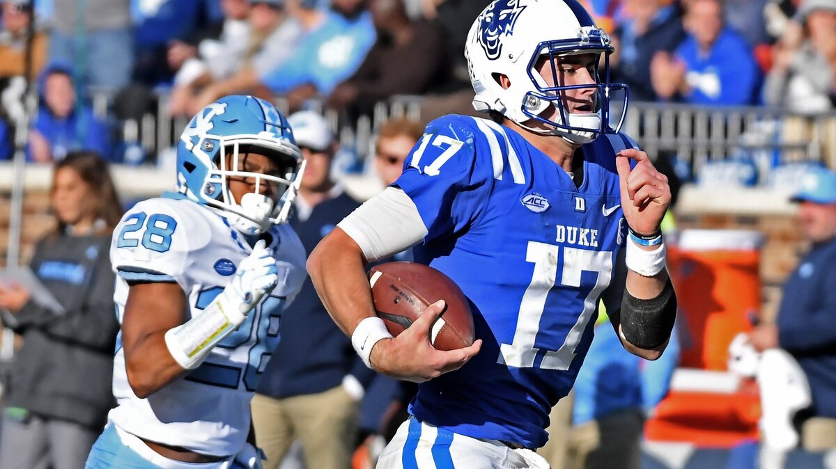 Duke quarterback Daniel Jones (17) is chased by UNC cornerback C.J. Cotman (28) in the third quarter as he sets up the Blue Devils final touchdown on a long run from midfield. Duke defeated UNC 42-35 at Wallace Wade Stadium In Durham, N.C., Saturday, Nov. 10, 2018