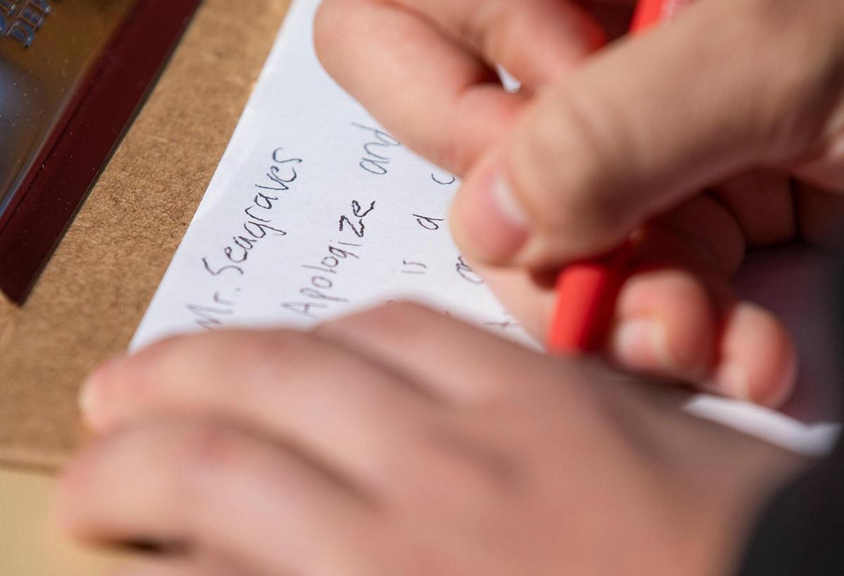 N.C. State students Sebastian Rios writes a letter to Chadwick Seagraves, a university employee accused of Proud Boys membership and online harassment, during a protest following an internal investigation that did not result in his firing, on Tuesday, Jan. 19, 2021, in Raleigh, N.C.
