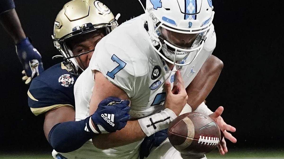 North Carolina quarterback Sam Howell (7) fumbles as he is tackled by Georgia Tech defensive lineman Jordan Domineck. during the first half of an NCAA college football game Saturday, Sept. 25, 2021, in Atlanta. Georgia Tech recovered the ball.