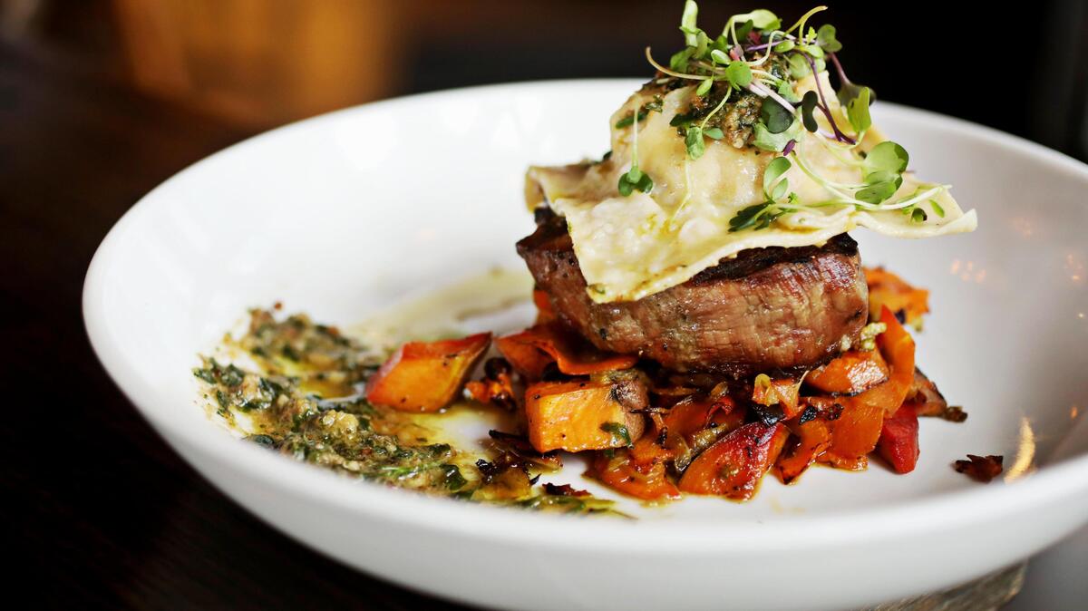 A surf and turf entree pairing of grilled house-cut filet mignon and homemade crab ravioli is solidly executed at STIR in Raleigh’s North Hills.