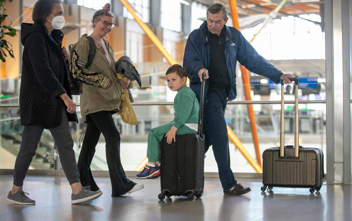 Five-year-old Milo Smith of Canton, Michigan, gets to ride on a rolling suitcase with his grandfather William Smith on Tuesday, November 22, 2022 at RDU International Airport in Morrisville, N.C. Milo and his mother Danielle Smith traveled to the Triangle to be with family during the Thanksgiving holiday.