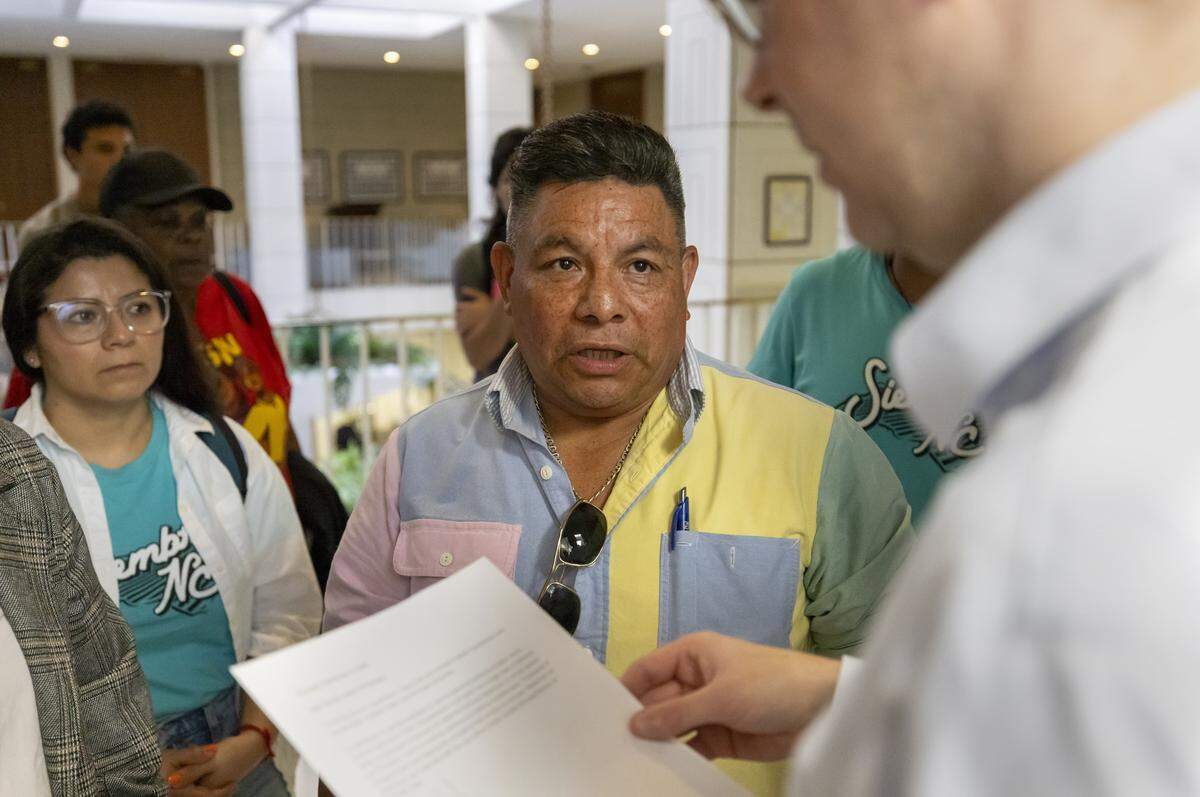 Turner Harrison from Senator Phil Berger’s office, accepts a letter from Duke University bus driver Luis Alonso Juárez and his supporters on Thursday, Sept. 4, 2025, in Raleigh. Juárez is a Honduran immigrant that could face deportation. 