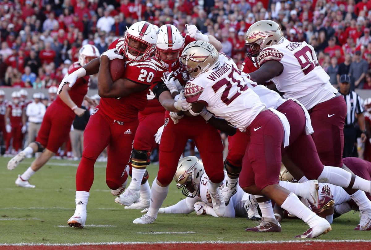 N.C. State running back Ricky Person (20) scores on a one-yard run during the first half of N.C. State’s game against Florida State at Carter-Finley Stadium in Raleigh, N.C., Saturday, Nov. 3, 2018.