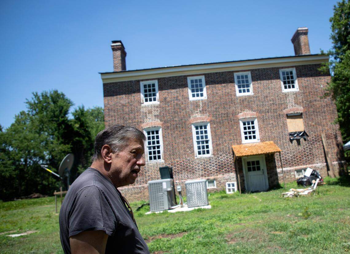 Bob Tucci walks along the exterior of the Duke-Lawrence House outside Rich Square, N.C., on June 15, 2022. Tucci is restoring the home, one of the oldest in North Carolina.