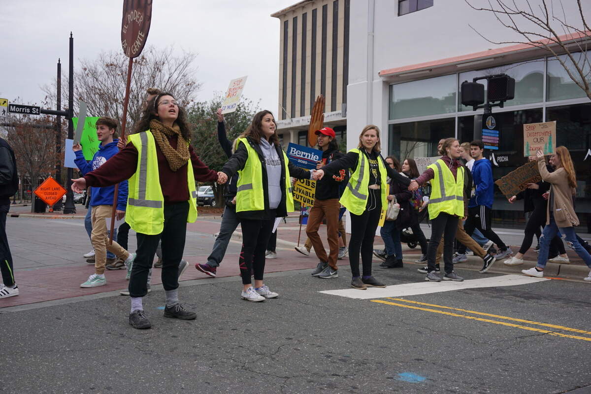 Organizers with Sunrise Movement block an intersection in downtown Durham so that fellow climate protesters could walk through, photographed on Dec. 6, 2019.
