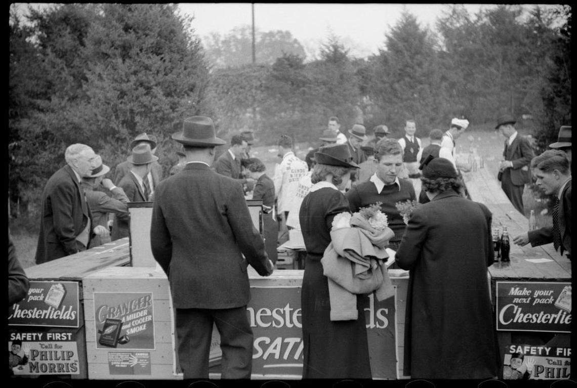 Fans buy concessions at a stand covered with cigarette advertising signs at the Duke-Carolina game in Durham, NC.