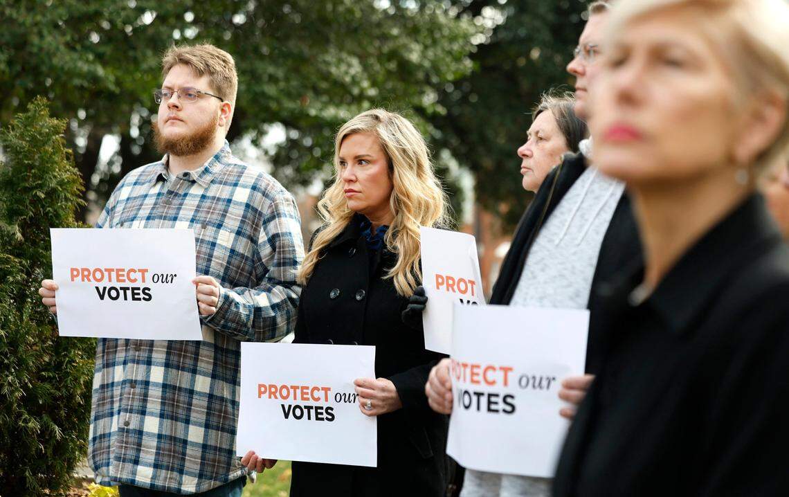 Thomas Benthall of Greenville, left, and Nellary Branch Moody, center, listen a press conference near the Justice Building in Raleigh, N.C., Monday, Jan. 27, 2025. Benthall and Branch Moody are two of the more than 65,000 North Carolina voters whose ballot N.C. Supreme Court candidate Jefferson Griffin is challenging.