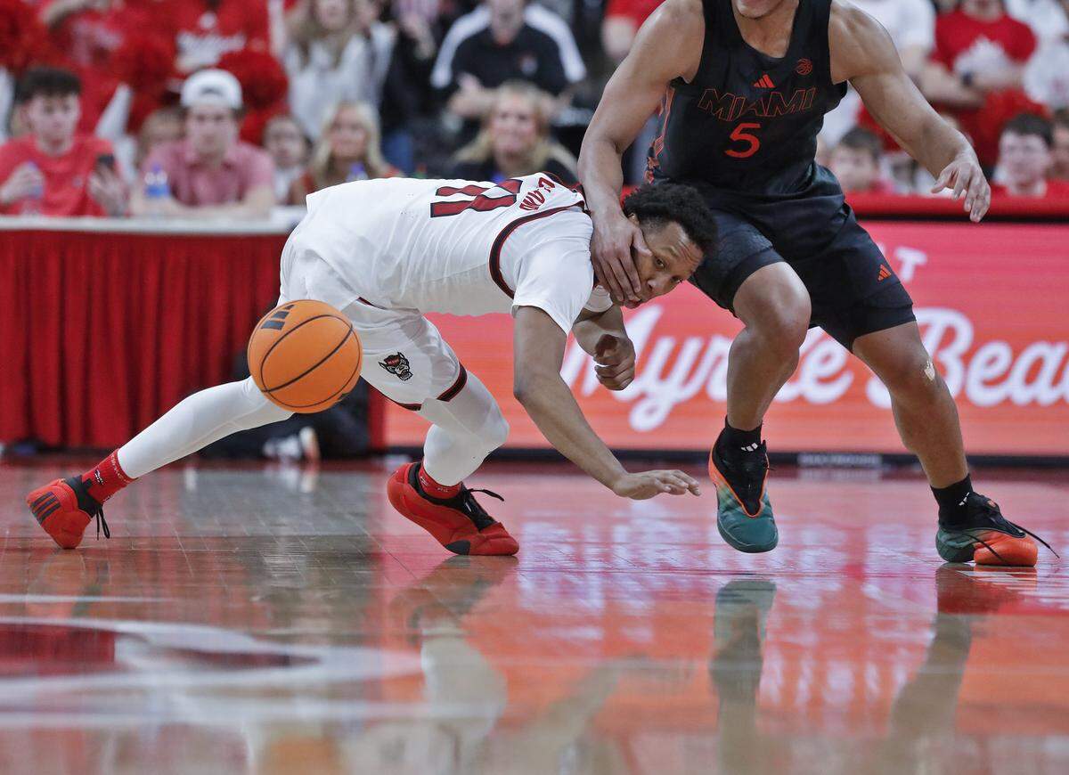 N.C. State’s Quadir Copeland and Miami’s Malik Raneau scramble for a loose ball during the second half of the Wolfpack’s 77-76 loss on Saturday, Feb. 14, 2026, at Lenovo Center in Raleigh, N.C.