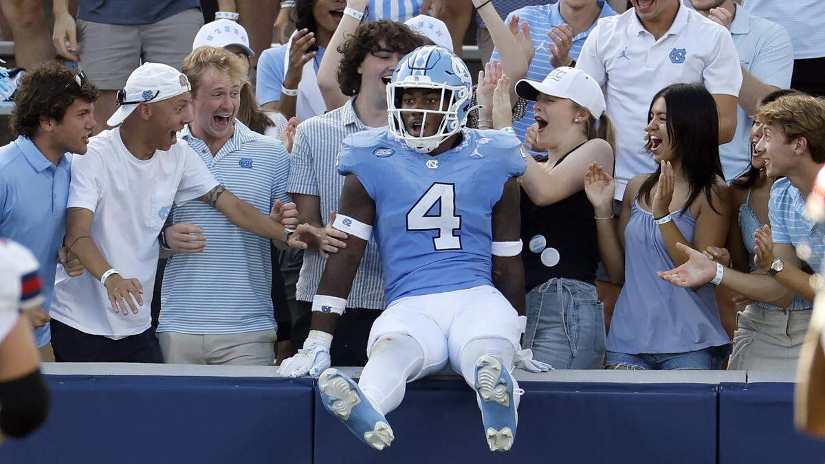 North Carolina linebacker Mikai Gbayor (4) jumps into the stands after scoring on a 61-yard fumble return during the second half of UNC’s 41-6 victory over Richmond at Kenan Stadium in Chapel Hill, N.C., Saturday, Sept. 13, 2025.