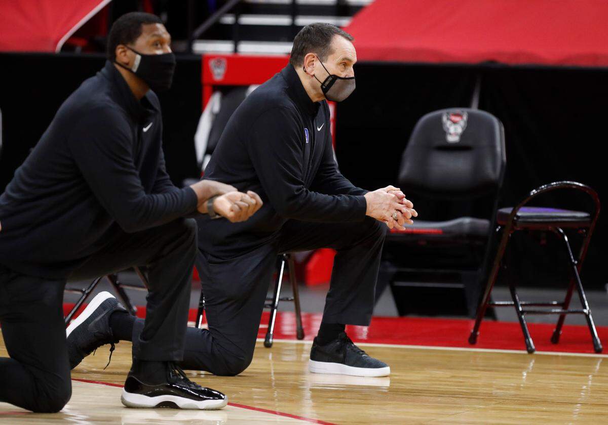 Duke head coach Mike Krzyzewski kneels during the pregame unity message before N.C. State’s game against Duke at PNC Arena in Raleigh, N.C., Saturday, February 13, 2021.