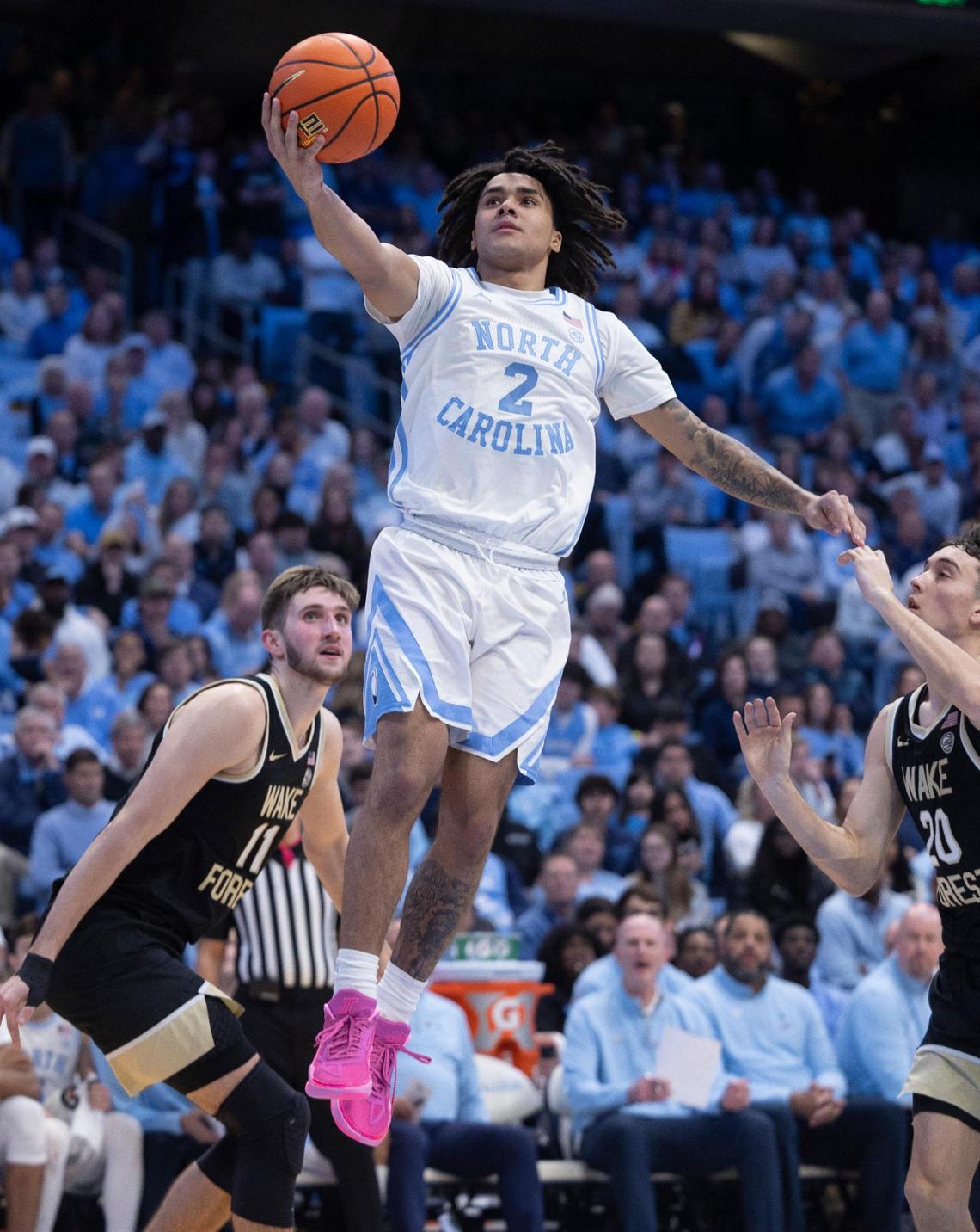 North Carolina’s Elliot Cadeau (2) drives to the basket between Wake Forest’s Andrew Carr (11) and Parker Friedrichsen (20) in the second half on Monday, January 22, 2024 at the Smith Center in Chapel Hill, N.C.