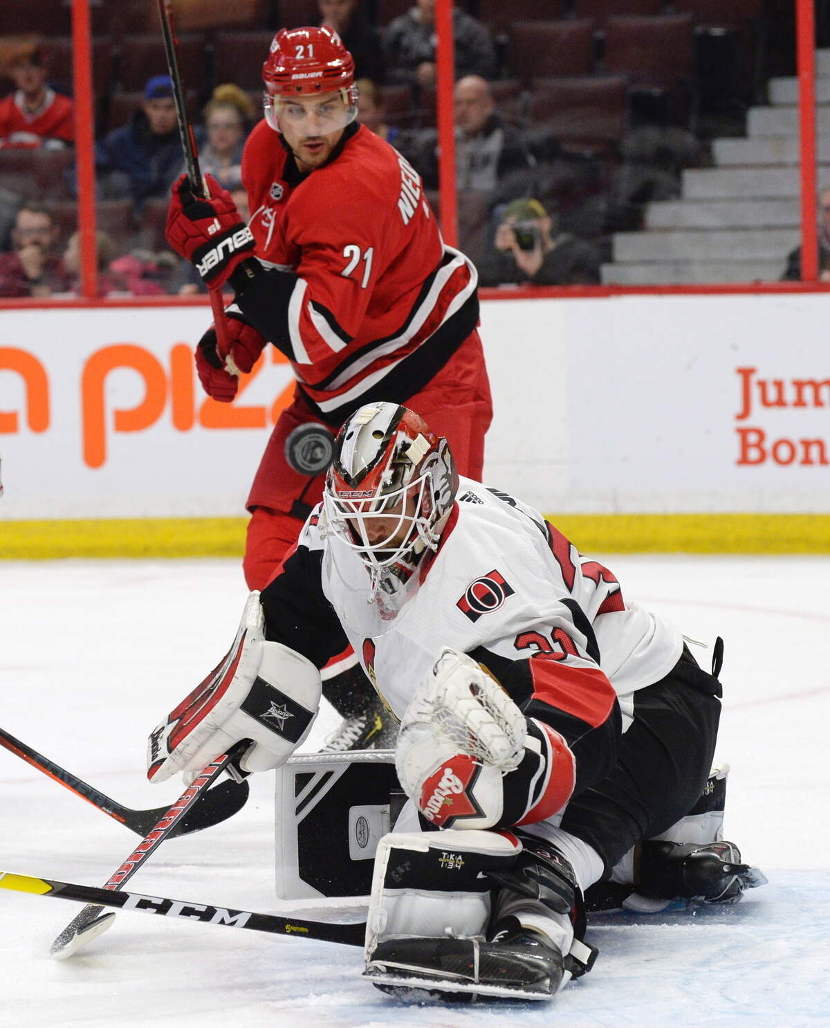 Ottawa Senators goaltender Anders Nilsson (31) makes a save as Carolina Hurricanes right wing Nino Niederreiter (21) looks on during the first period of an NHL hockey game, Tuesday, Feb. 12, 2019, in Ottawa, Ontario. (Adrian Wyld/The Canadian Press via AP)