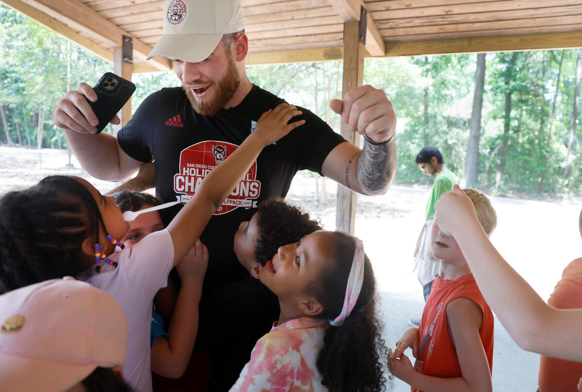 N.C. State quarterback Devin Leary is surrounded by Raleigh Parks and Recreation summer campers as he says goodbye after serving snow cones to the campers Wednesday, June 22, 2022. As part of the Wolfpack’s ‘D Leary Delivers’ campaign, Leary along with offensive linemen Bryson Speas, Tim McKay and Derrick Eason brought a SnoCone truck to two Raleigh camps, hung out with the campers and then made snow cones for them.