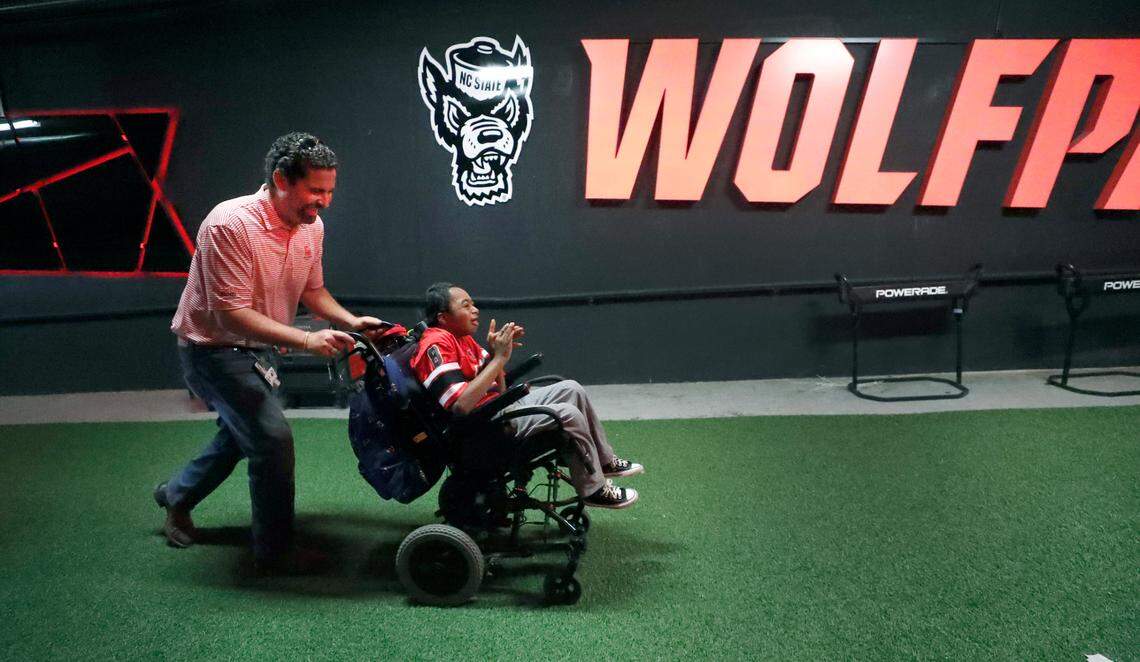 Savage Wolves NIL Co-Owner Tom Livolsi pushes Grayson Ketchie up towards the Murphy Center after watching the football team take the field before N.C. State’s game against Marshall at Carter-Finley Stadium in Raleigh, N.C., Saturday, Oct. 7, 2023.