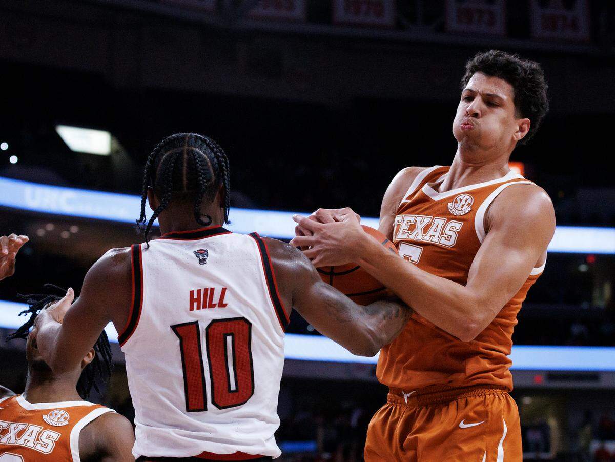 N.C. State’s Marcus Hill and Texas’ Kadin Shedrick battle for a rebound during the first half of the Wolfpack’s 63-59 loss on Wednesday, Dec. 4, 2024, at Lenovo Center in Raleigh, N.C.