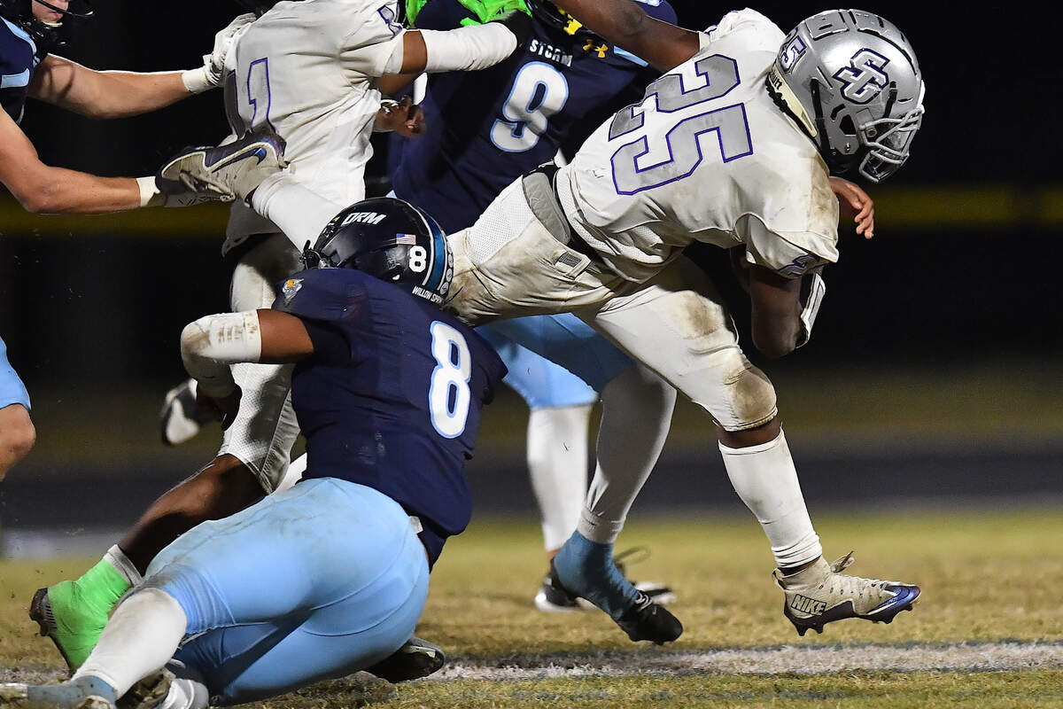 South Garner running back Micah Scurlock (25) rushes for yardage against Willow Spring’s Kordell Jones (8) during the second half. The Willow Spring Storm and the South Garner Titans met in a football game in Fuquay-Varina. N.C. on October 18, 2024.