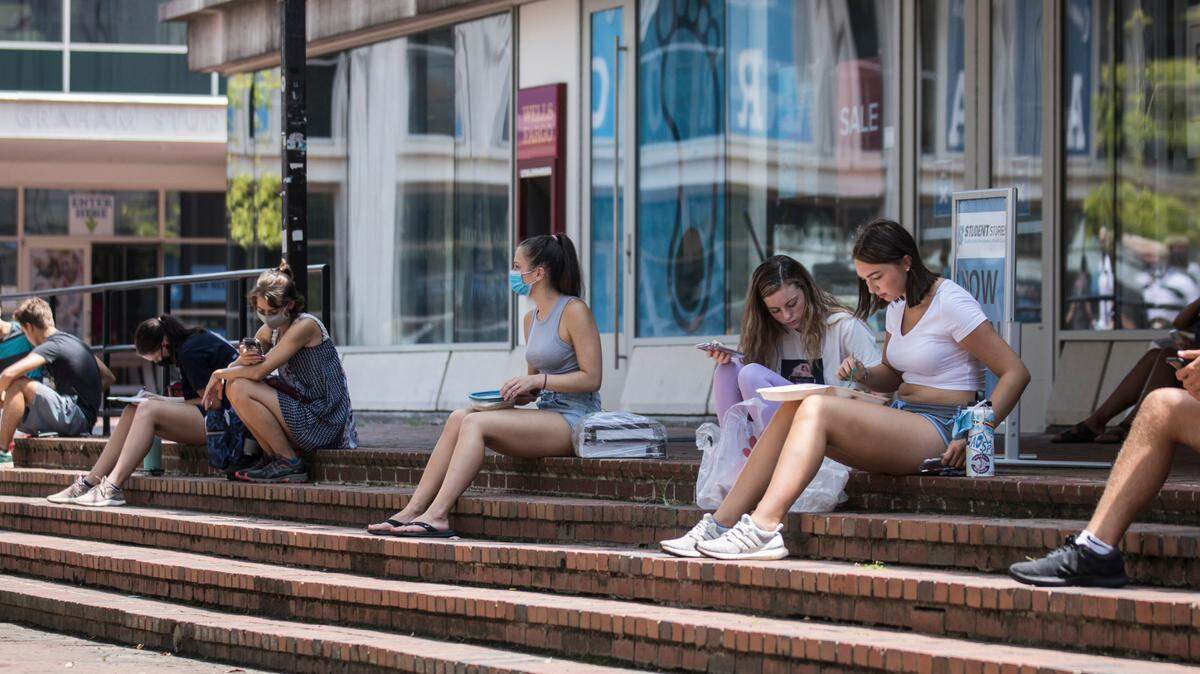 Students maintain physical distance as they line the perimeter of “The Pit” on UNC-Chapel Hill’s campus during breaks between classes on Monday, Aug. 10, 2020.