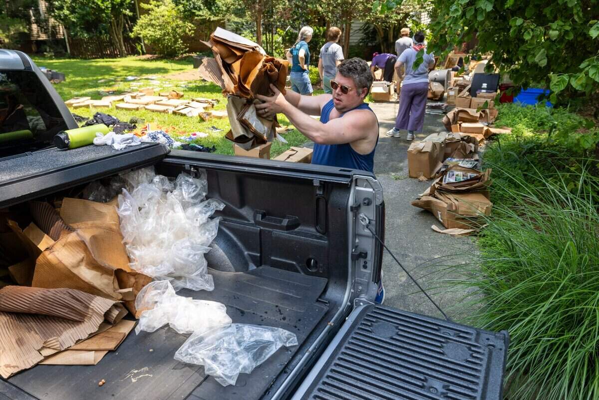 Taylor Poston loads debris from a storm damaged home on Ridgefield Road on Tuesday, July 8, 2025 in Chapel Hill, N.C. The home was damaged by Tropical Strom Chantal from the flood waters of Booker Creek.