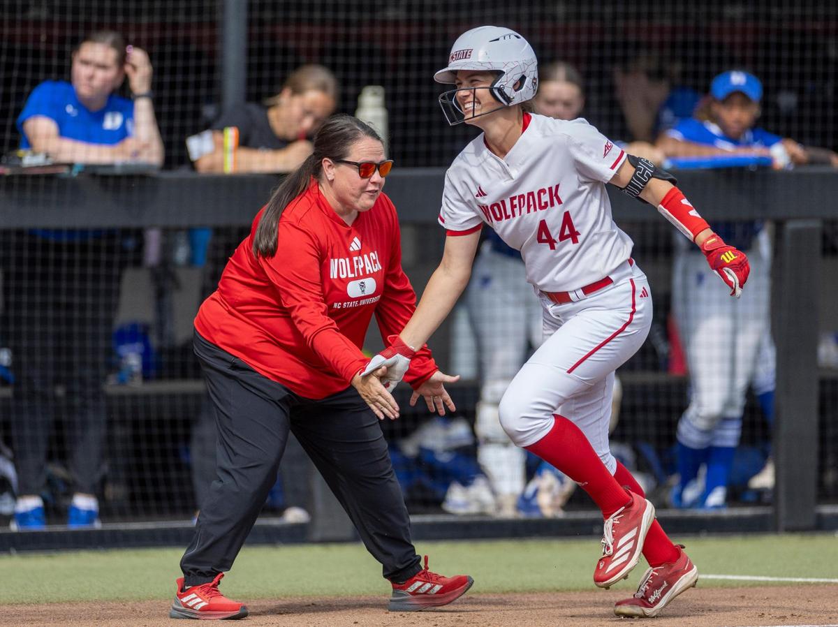 N.C. State softball coach Lindsay Leftwich congratulates outfielder Taylor Ensley (44) as she rounds third base, after connecting for a home run in the first inning against Duke on Friday, April 25, 2025 at Dail Softball Stadium in Raleigh, N.C.