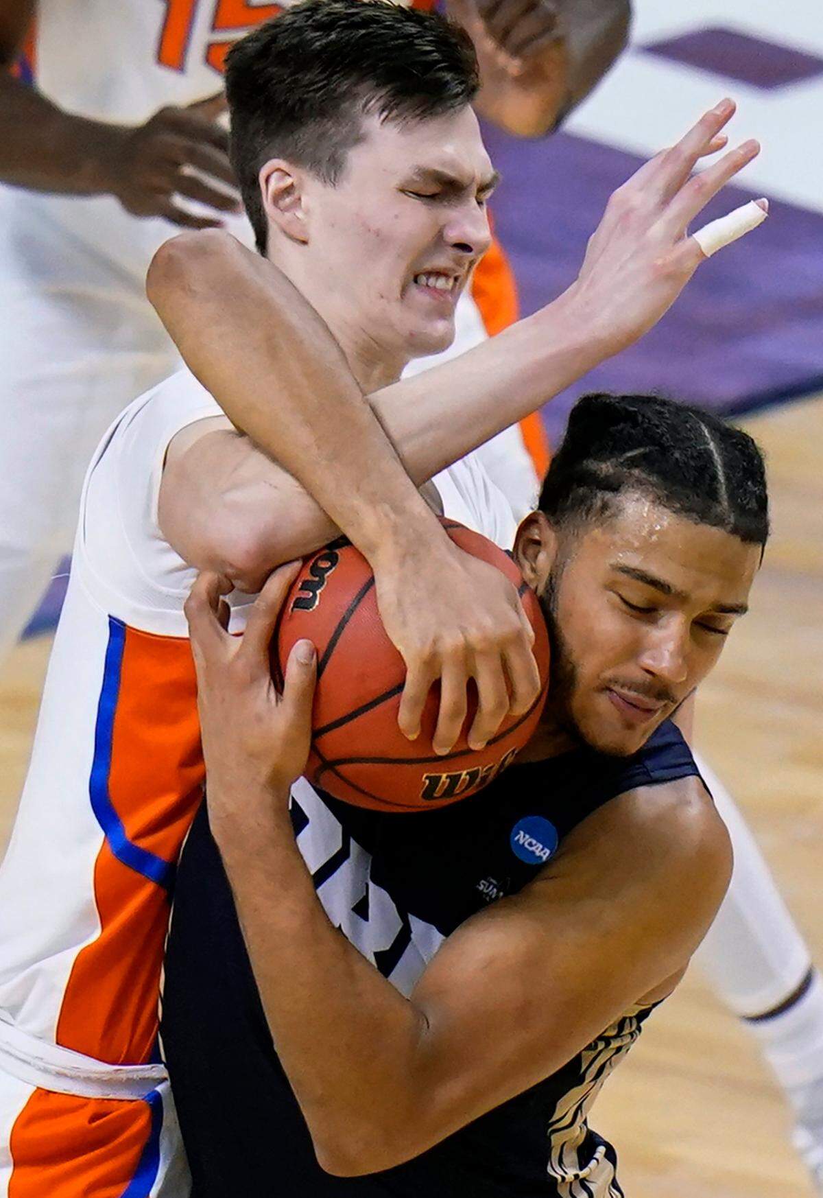 Florida forward Colin Castleton, left, fights for a loose ball with Oral Roberts forward Kevin Obanor during the second half of a college basketball game in the second round of the NCAA tournament at Indiana Farmers Coliseum, Sunday, March 21, 2021 in Indianapolis. 
