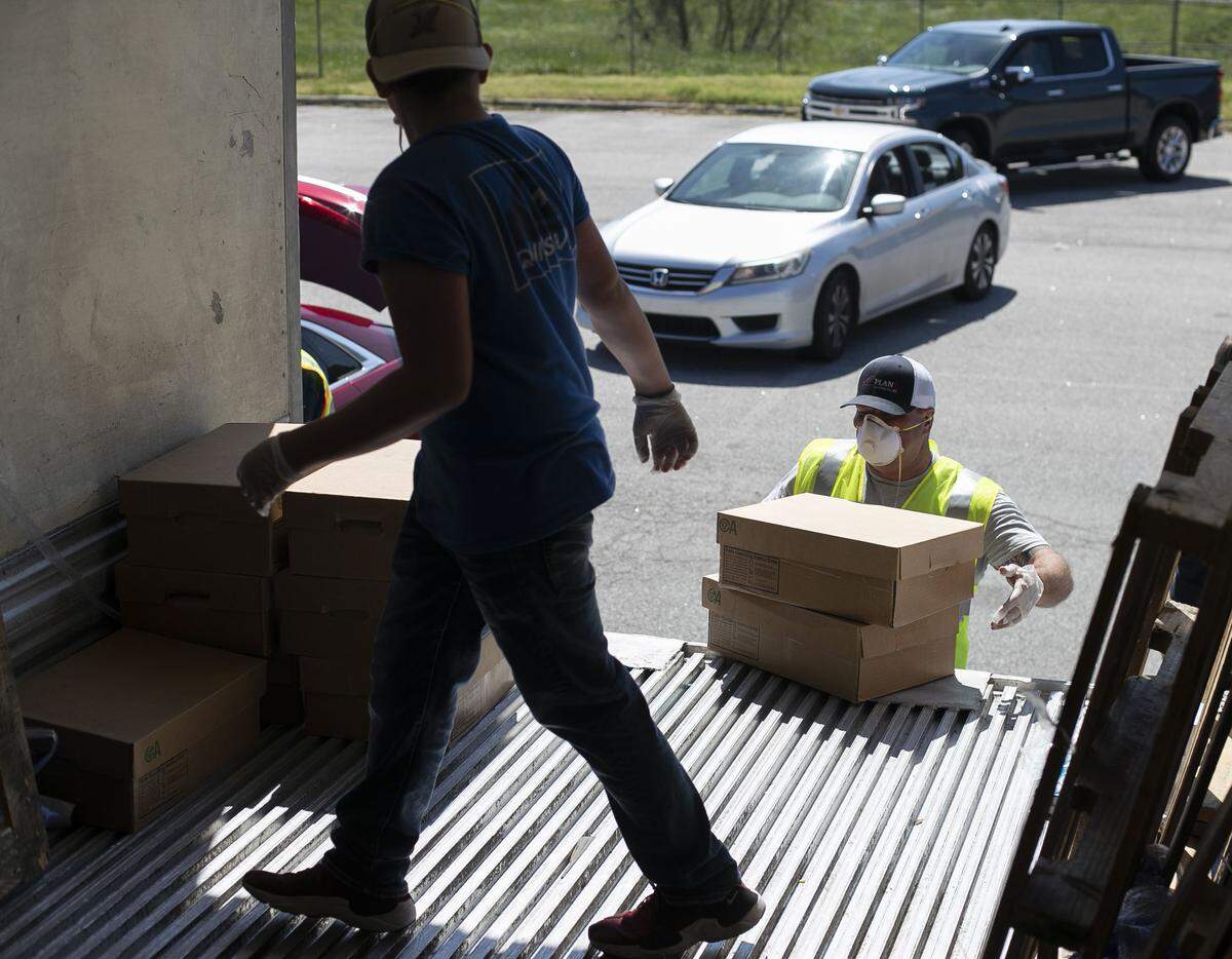 Ashley Duff picks up two more cases of chicken to deliver to a customer during a sale at the North Carolina State Farmers Market on Thursday morning April 16, 2020 in Raleigh, N.C. Chicken from House of Raeford was sold by the case with some people waiting in line for several hours to make their purchases. By mid-day Thursday 1000 cases had been sold and another tractor trailer load arrived enabling the sale to continue into the afternoon.