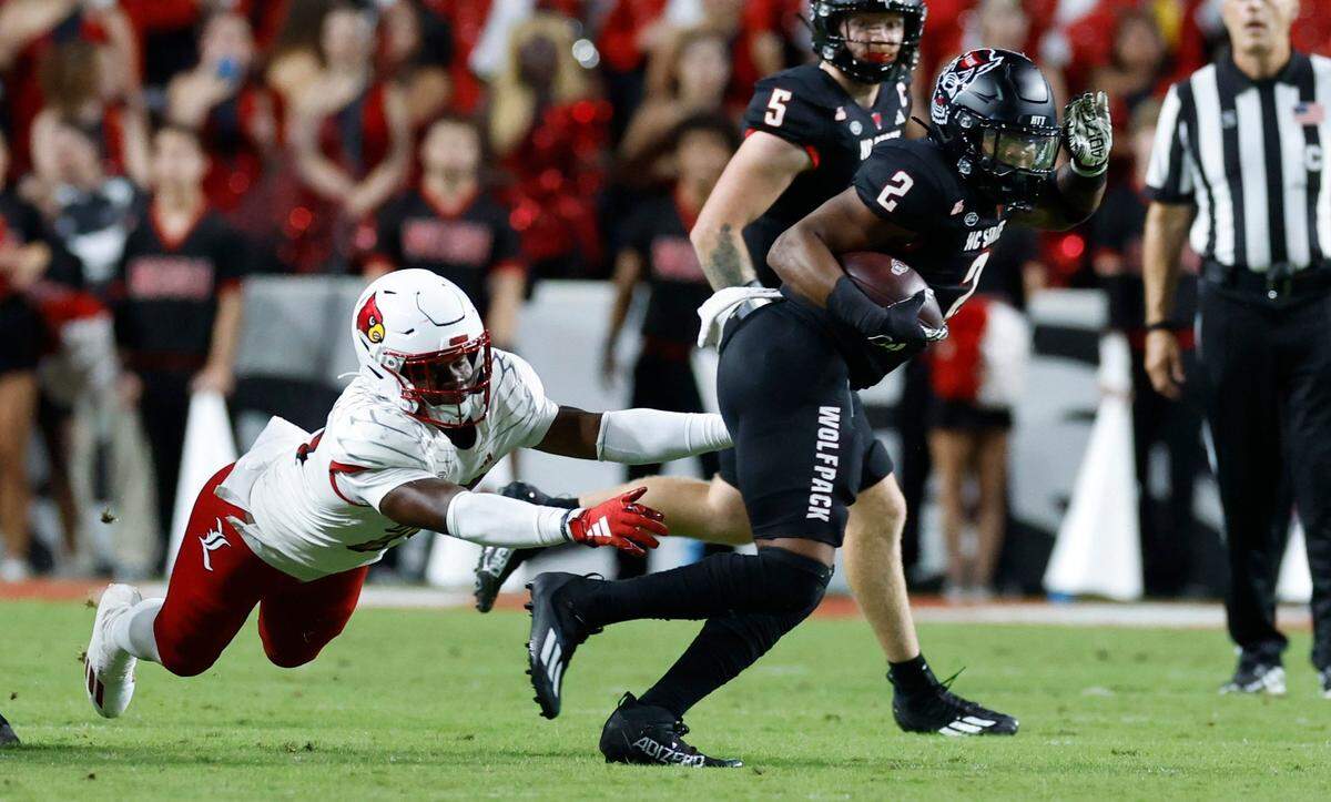 N.C. State running back Michael Allen (2) escapes from Louisville linebacker Jaylin Alderman (24) during the first half of N.C. State’s game against Louisville at Carter-Finley Stadium in Raleigh, N.C., Friday, Sept. 29, 2023.