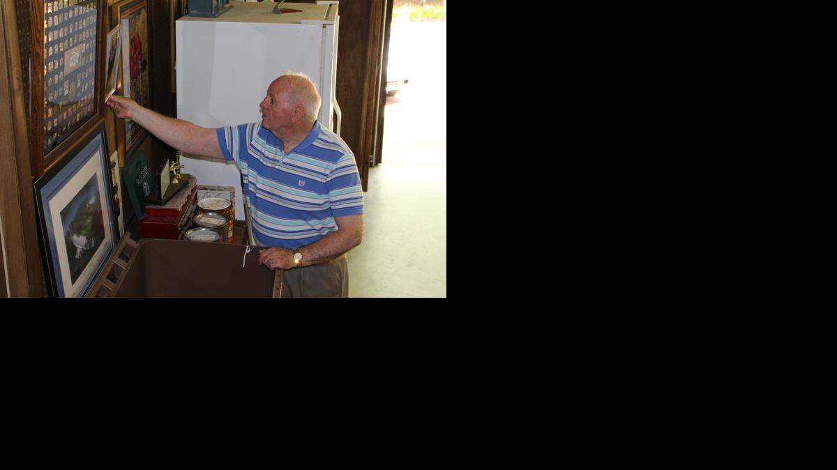 Koka Booth, who served as Cary’s mayor for 12 years until 1999, checks out the photos hanging on the walls of the garage at his Cary home. Booth led the town through years of major growth.