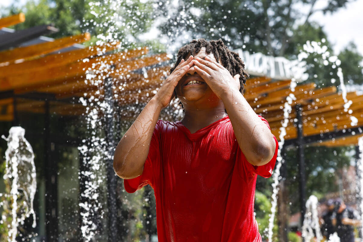 Ariana Nabors cools off in the splash pad at Moore Square with her brother Ishmael on Monday, June 29, 2026, in downtown Raleigh.
