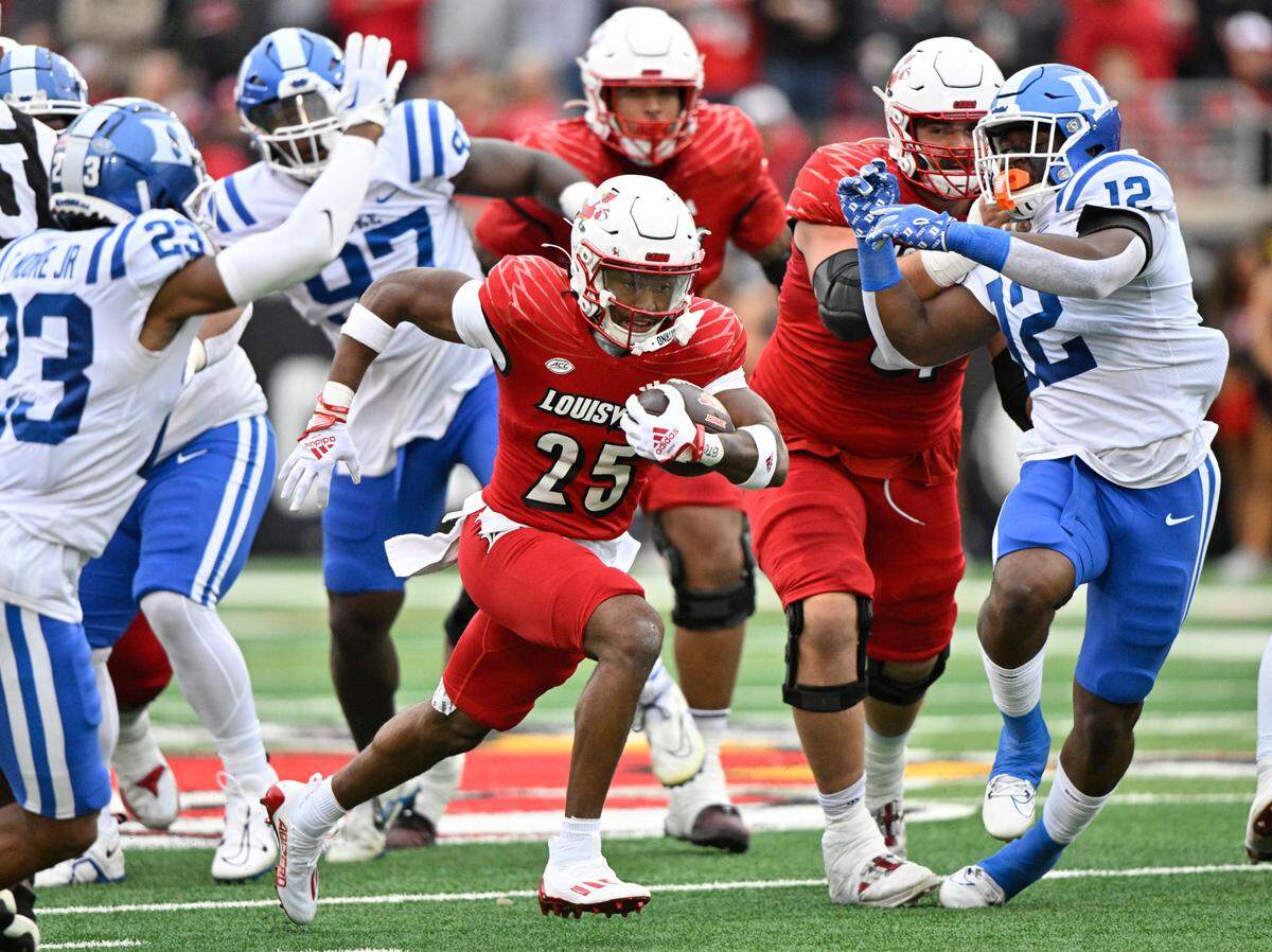Louisville Cardinals running back Jawhar Jordan (25) runs the ball against Duke Blue Devils safety Terry Moore (23) during the first quarter at L&N Federal Credit Union Stadium.