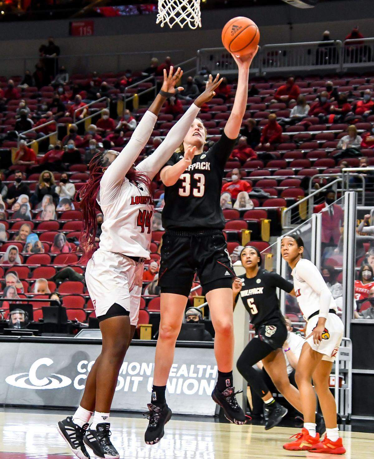 N.C. State’s Elissa Cunane (33) shoots as Louisville’s Olivia Cochran (44) defends during the Wolfpack’s game against Louisville at KFC Yum! Center in Louisville, Ky. Monday, February 1, 2021.