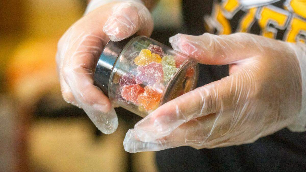 Amado Ruiz-Perez fills jars with CBD gummies at Cannabliss Dispensary, on Wednesday, July 7, 2021, in Chapel Hill, N.C.