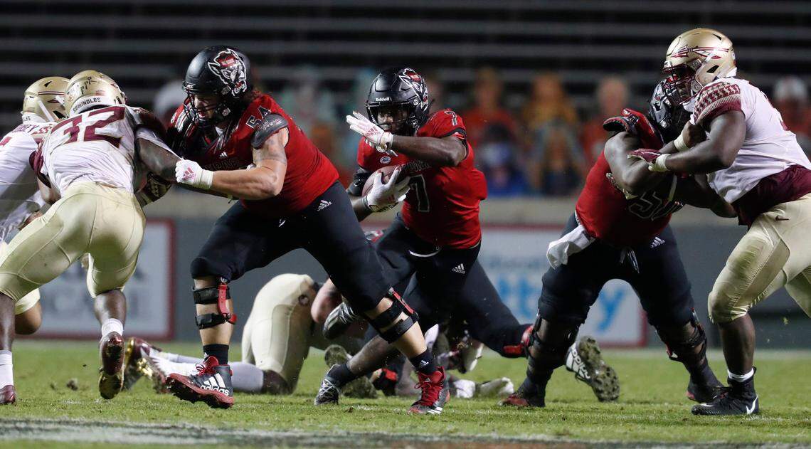 N.C. State running back Zonovan ‘Bam’ Knight (7) goes through the hole opened up by Dylan McMahon (54), left, and Grant Gibson (50) during the second half of N.C. State’s 38-22 victory over Florida State at Carter-Finley Stadium in Raleigh, N.C., Saturday, Nov. 14, 2020.