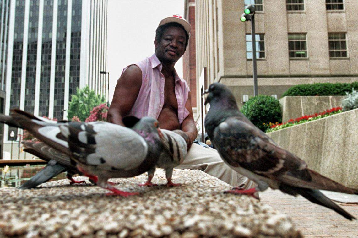 Walther Chavis of Raleigh, who called himself “The Birdman”, feeds pigeons in front of the Wake County Courthouse on the Fayetteville Street Mall in 1999.