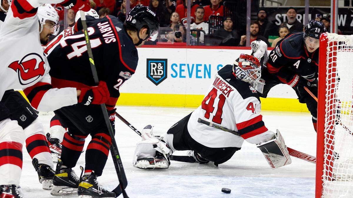 Carolina Hurricanes’ Sebastian Aho (20) passes the puck past New Jersey Devils goaltender Vitek Vanecek (41) for a waiting Seth Jarvis (24) during the second period of an NHL hockey game in Raleigh, N.C., Tuesday, Jan. 10, 2023. (AP Photo/Karl B DeBlaker)