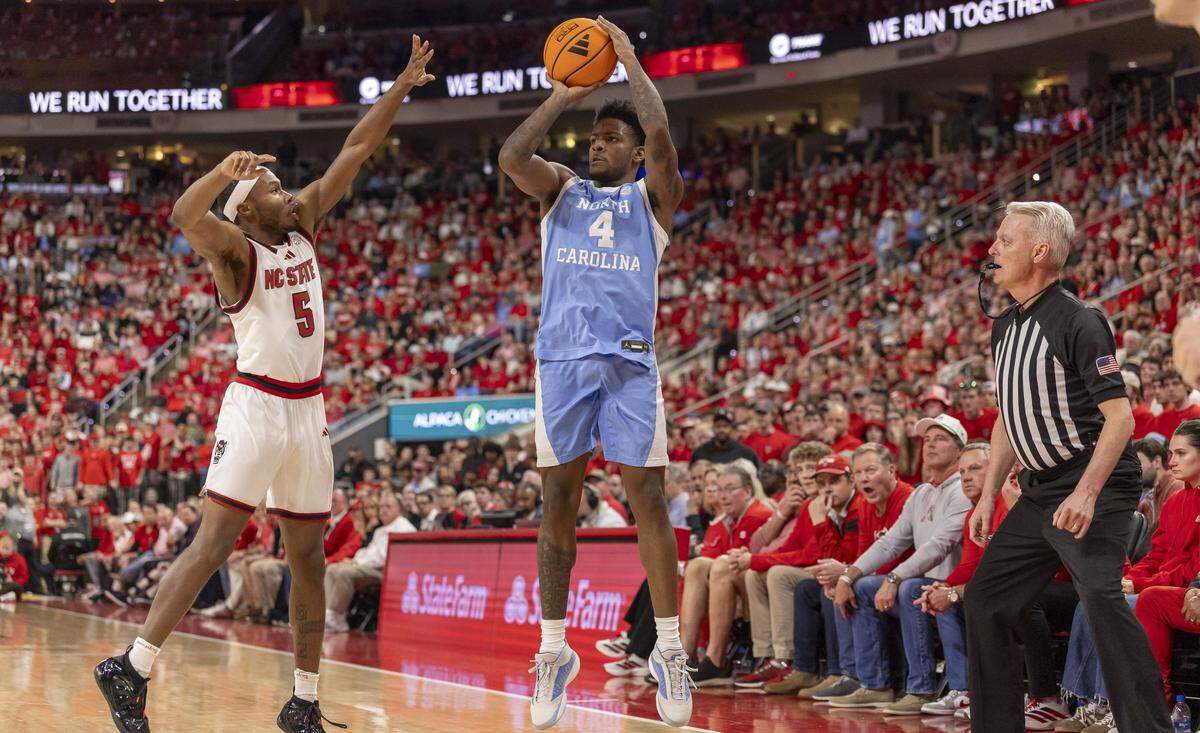 North Carolina guard Jaydon Young (4) puts up a three-point shot against N. C. State guard Tre Holloman (5) in the second half on Tuesday, February 17, 2026 at Lenovo Center in Raleigh, N.C.